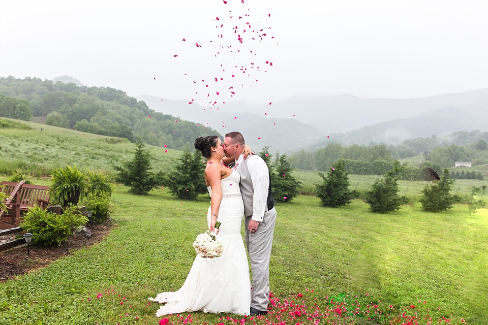 Bride and groom share kiss with petal toss