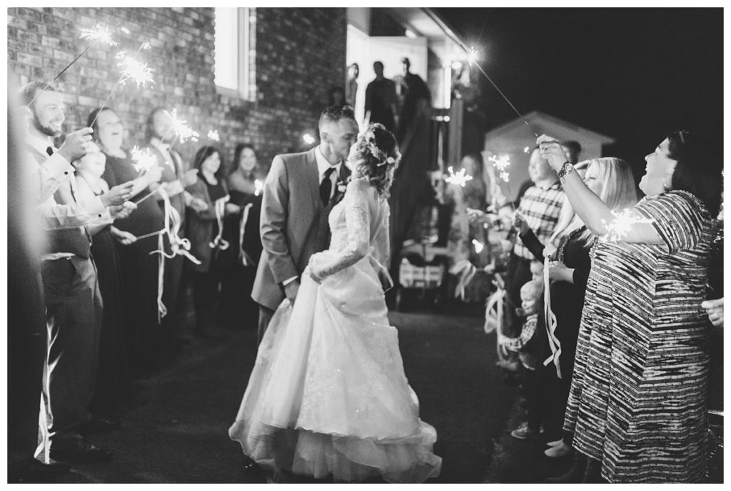 The bride and groom share a kiss during their sparkler exit at Victory Baptist Church