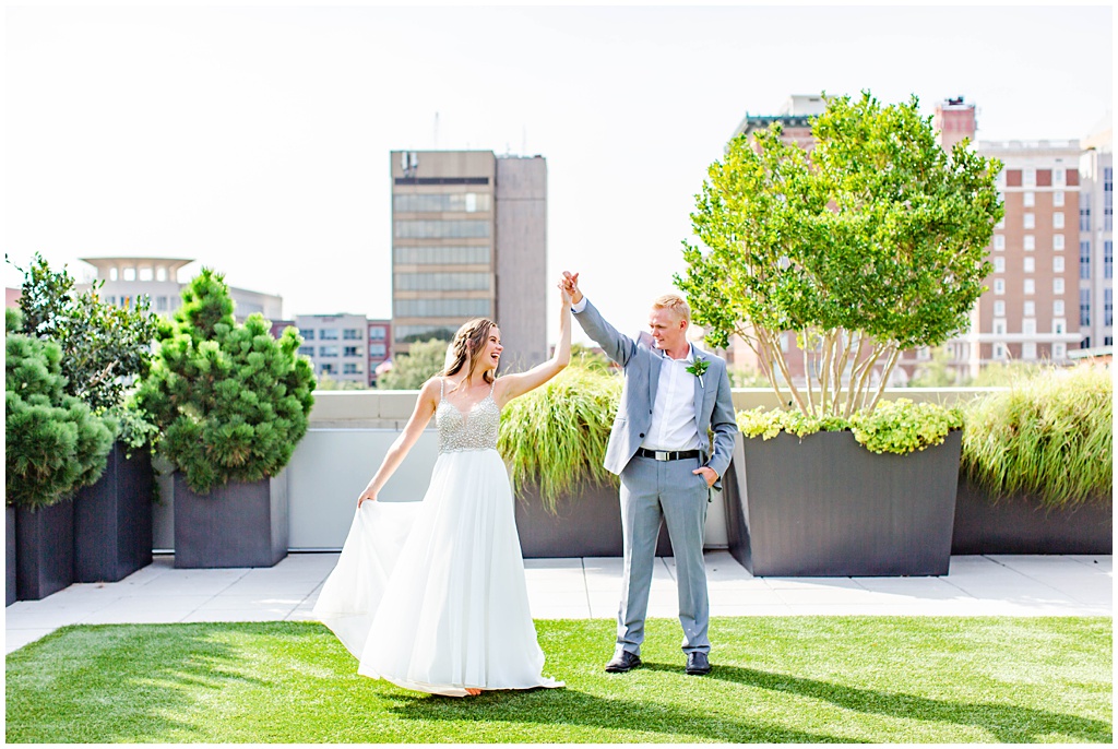 Groom twirling the bride on a city roof top garden