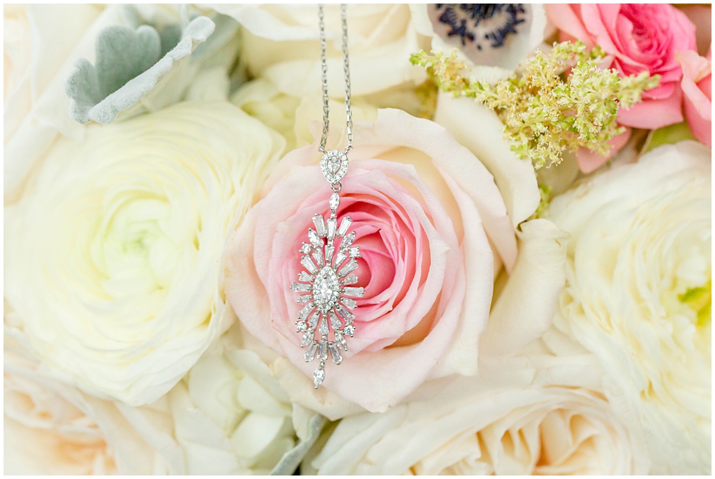 Glamorous diamond necklace laying on pink roses