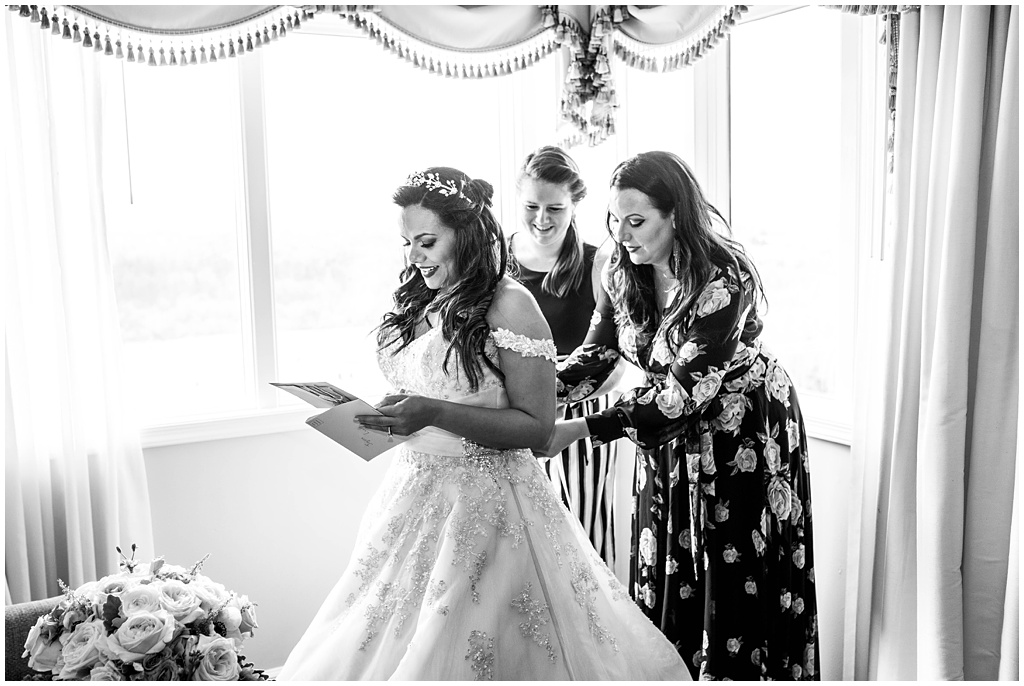 black and white image of the bride reading a letter on her wedding day