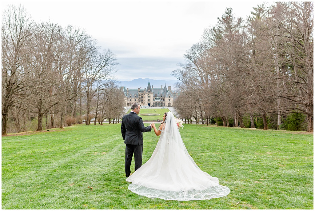 Bride and groom spring wedding portraits on the hill with views of the Biltmore Estate