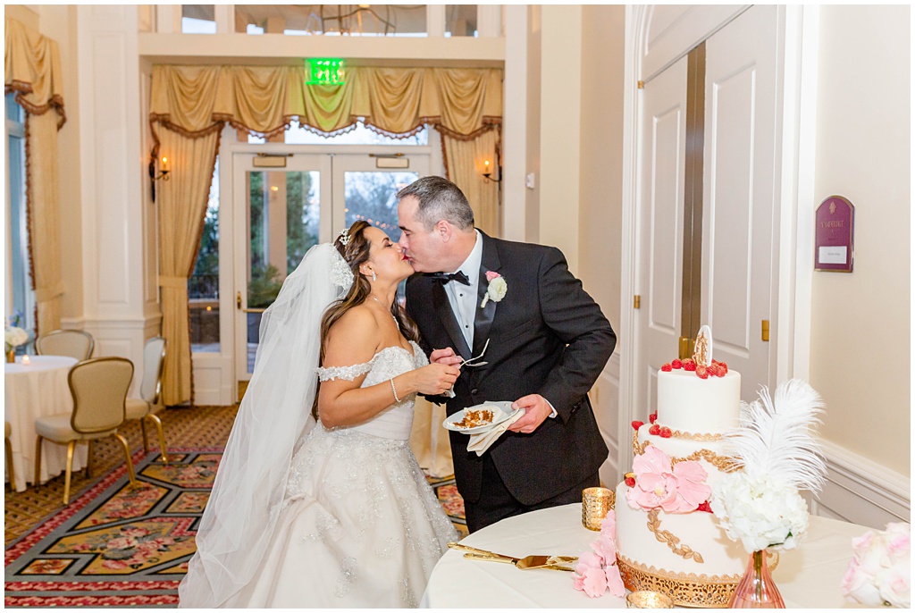 The bride and groom cutting the cake together at their wedding reception at the Inn at Biltmore Estate