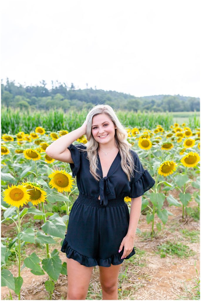 Senior portrait session posing in a sunflower field