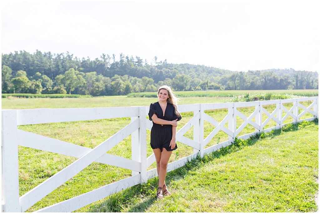 Outdoor senior portrait session with a white fence