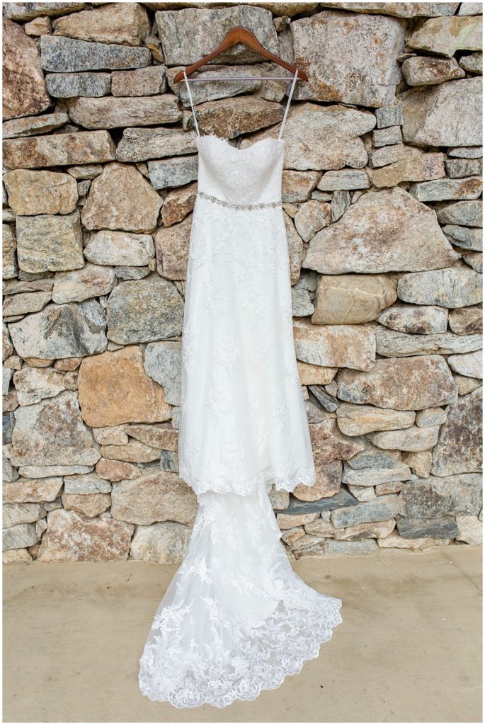 Wedding dress hanging on stone wall