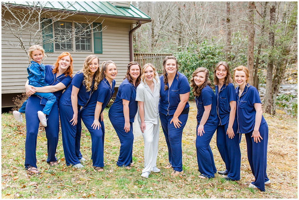 The bride with all of her bridesmaids in matching navy pajamas