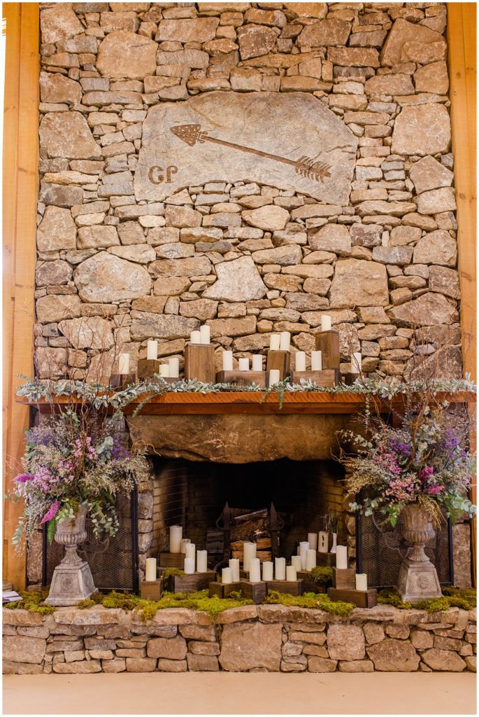 Beautiful stone fireplace with candles, lavender, and greenery.
