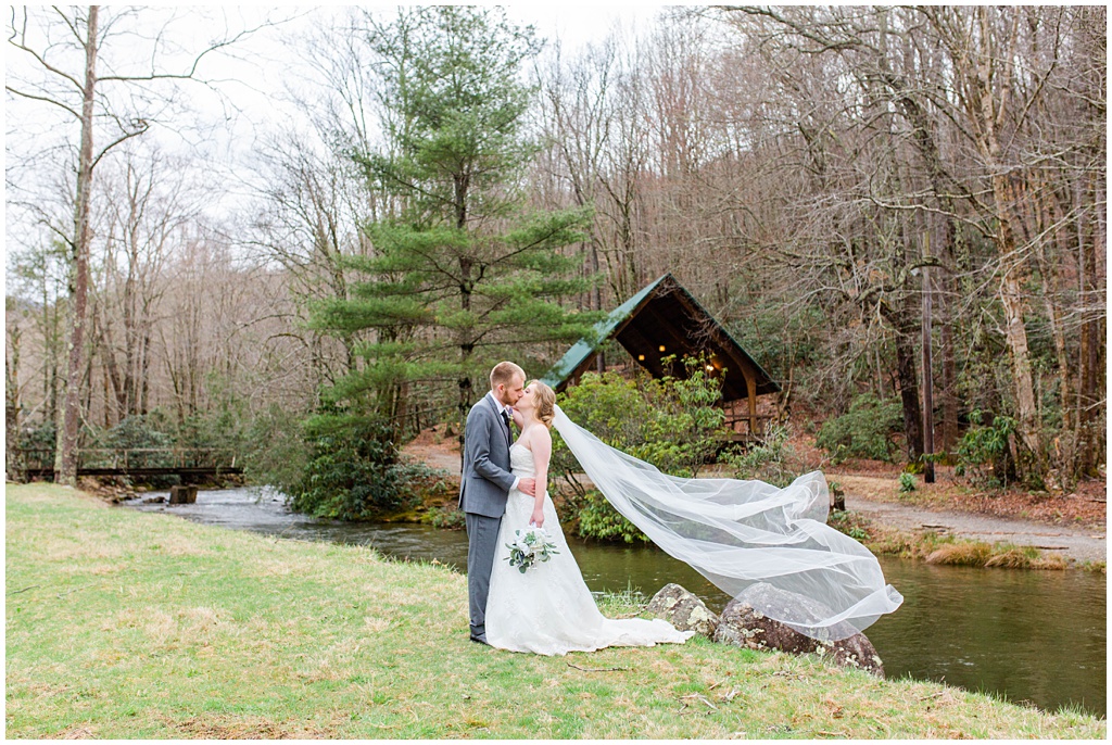 Bride and groom portraits at Camp Daniel Boone with the veil flying in the wind.