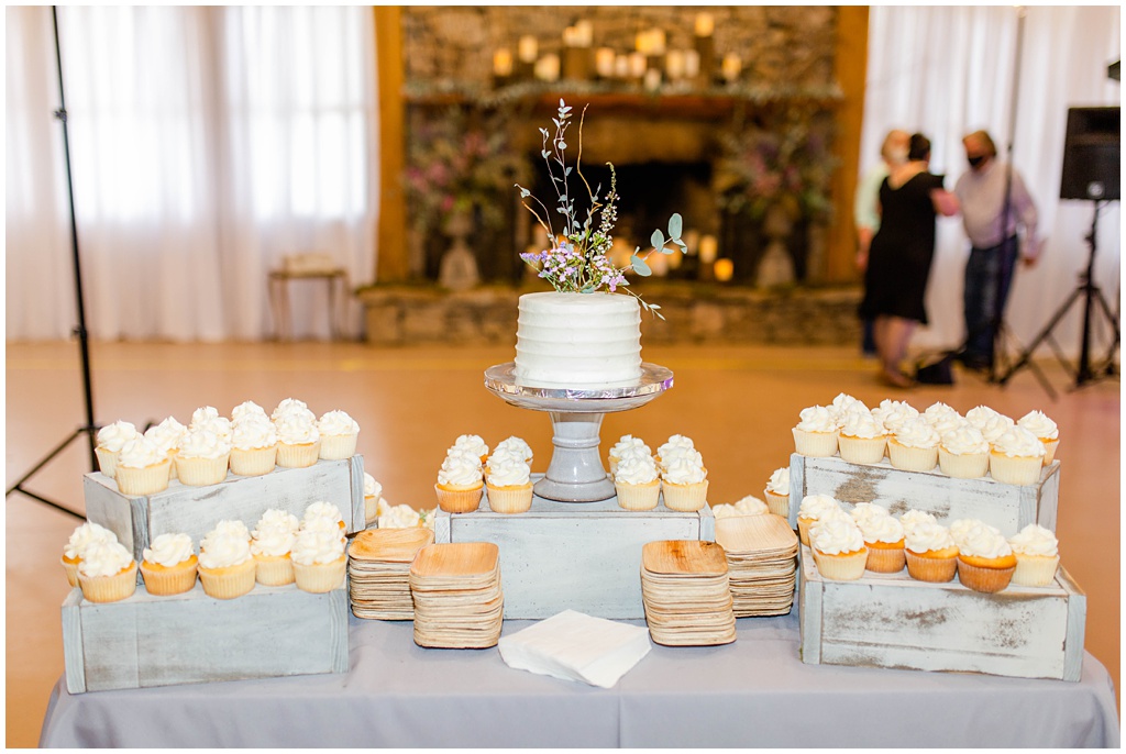 The dessert table covered with vanilla cupcakes.