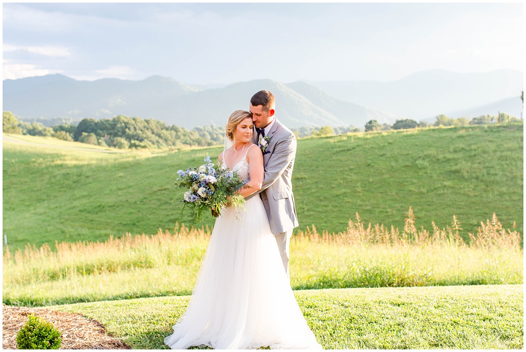 Bride and groom sunset portraits with blue bouquet and rolling mountain views at The Ridge | Asheville Wedding Photographer