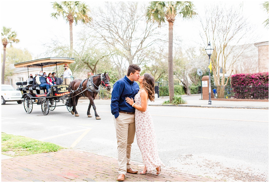 Rainbow row engagement photos in downtown Charleston with a horse carriage.
