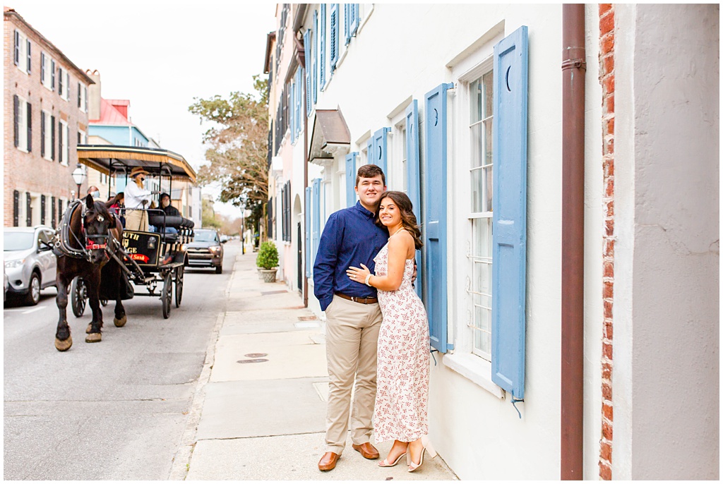 Engagement photos in downtown Charleston on Tradd Street with a horse carriage.