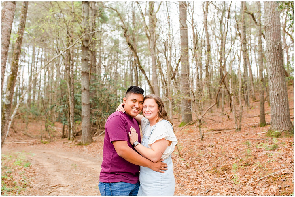 Couple hugging in the woods of the mountains for rustic couples portraits.