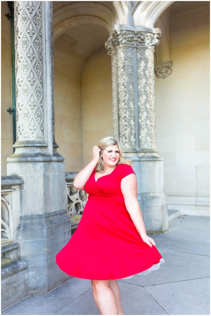 Madison twirls in a red dress against the stone of the Biltmore Estate home.