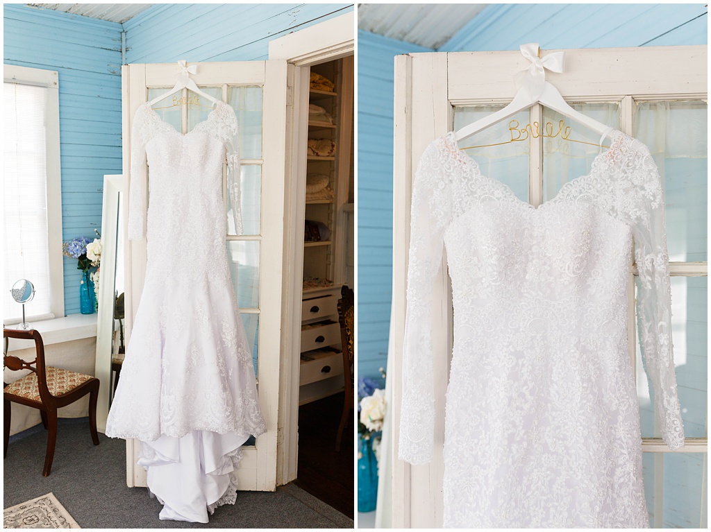 The bride's lace wedding dress hanging at the venue.