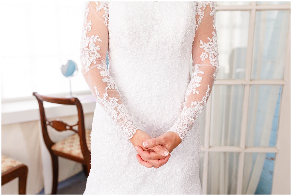 The bride clasps her hands as she anticipates seeing her groom.