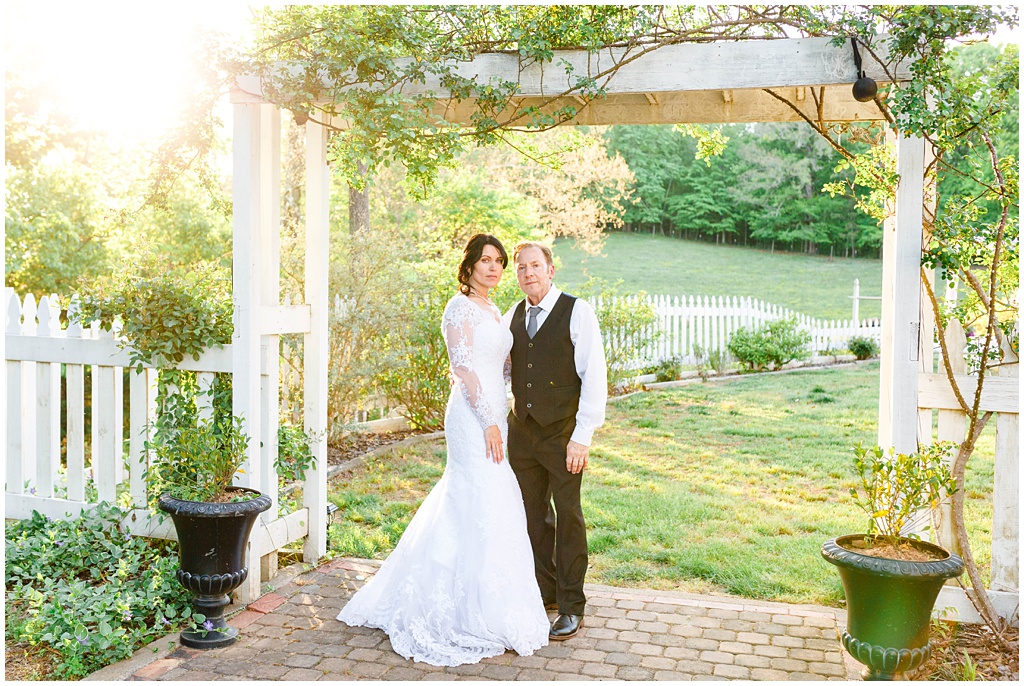 Bride and groom portrait under the arbor at New Beginnings Historic Farm.