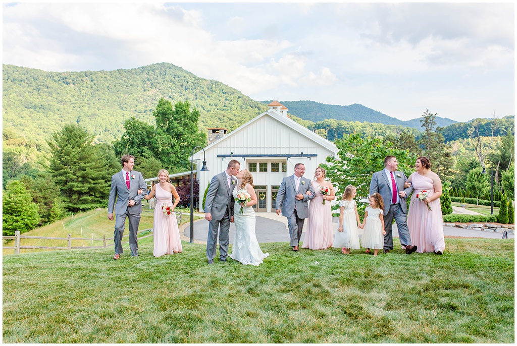 The bridal party walking together on top of a hill at Chestnut Ridge with Mountains in the background.