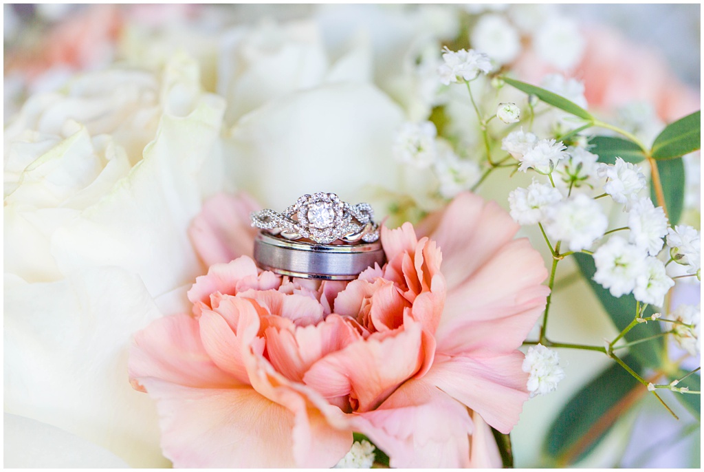 The three wedding bands stacked on top of a flower.