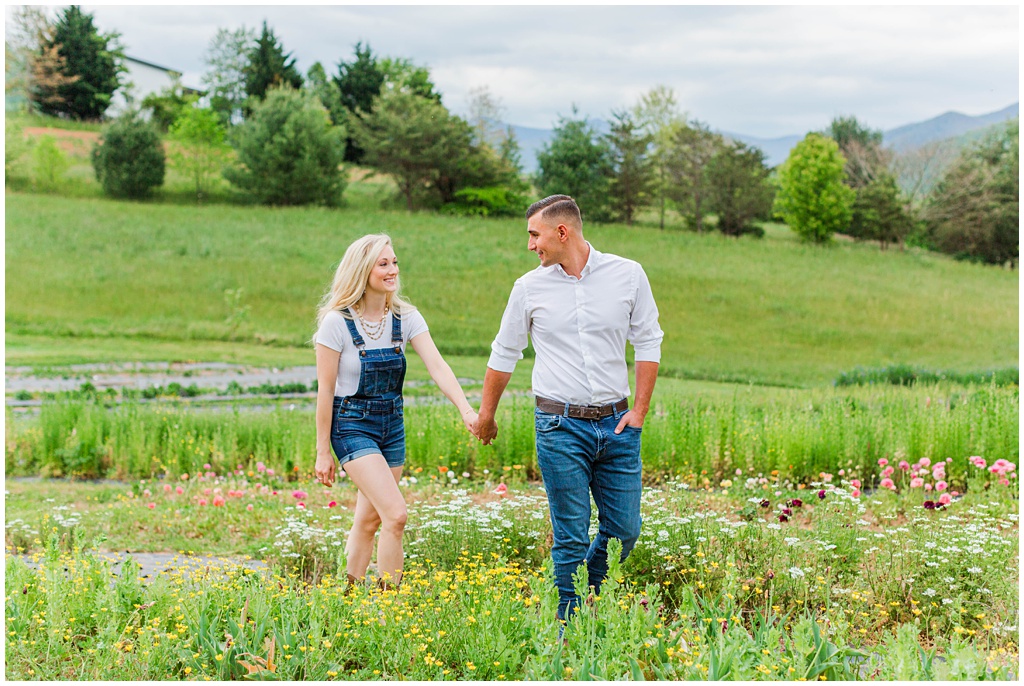 Engagement photo inspiration walking through a field of flowers.