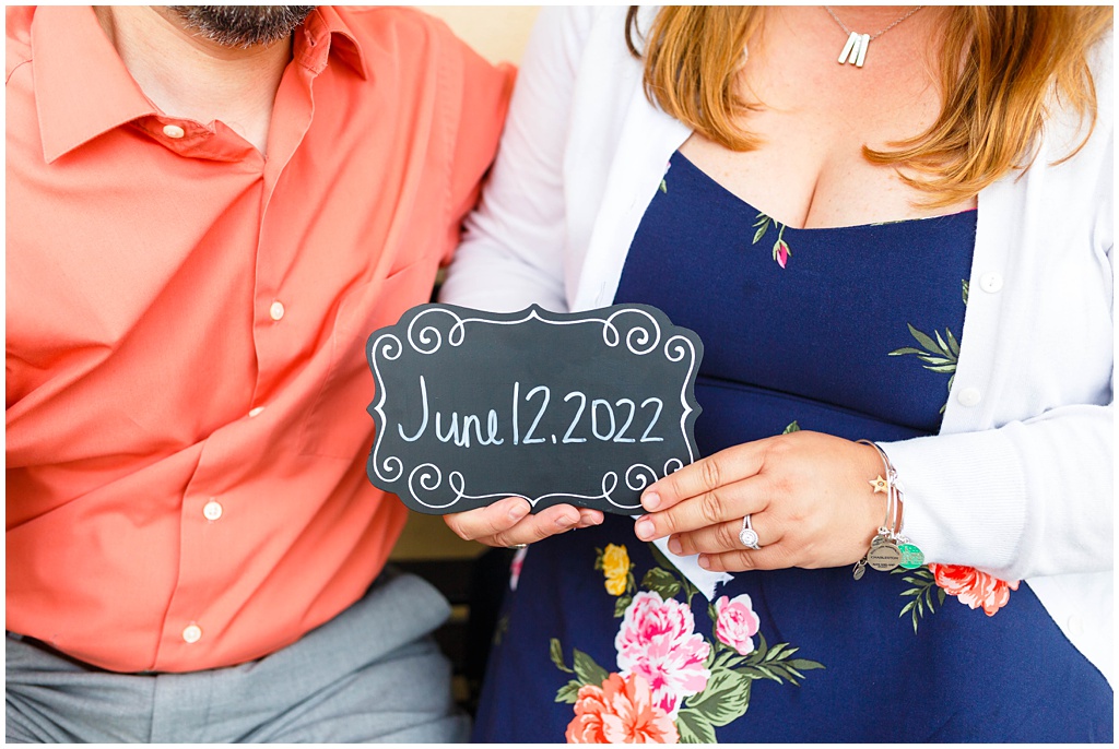 The couple holds up a chalkboard sign announcing their wedding date.