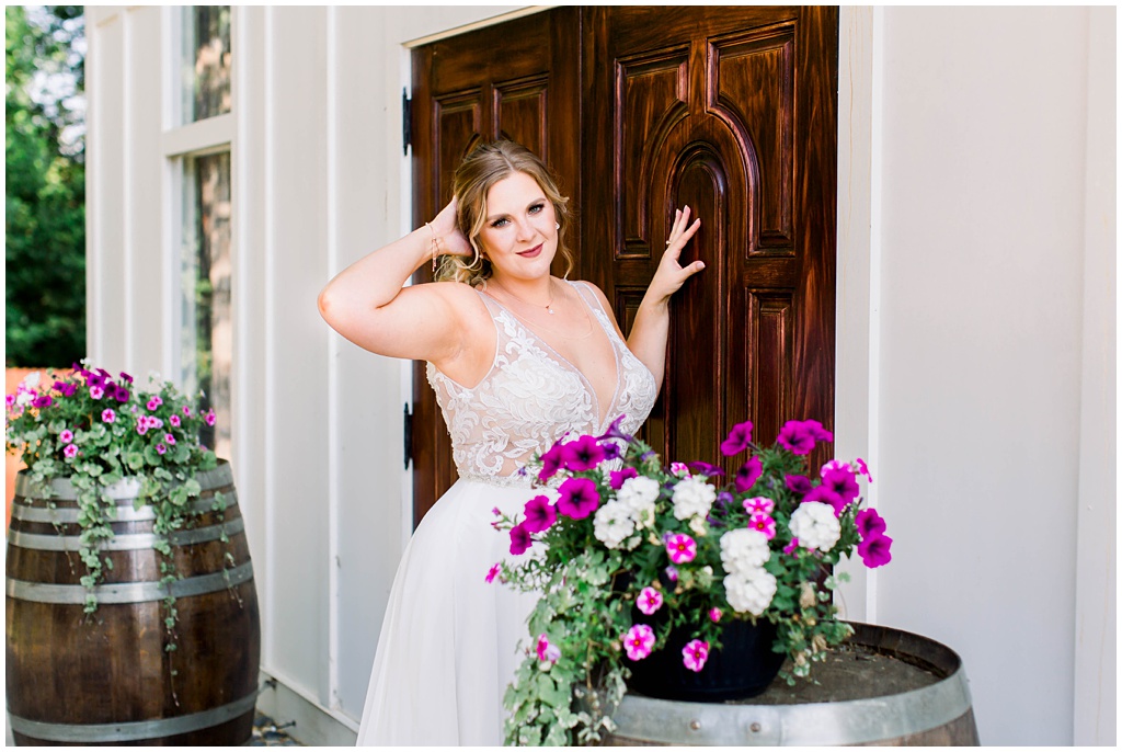 The bride leans up against the wooden door of the chapel.