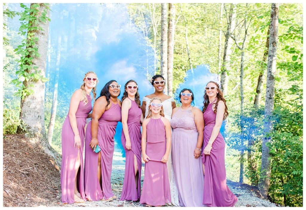 Bridesmaids photo with a blue smoke bomb and matching sunglasses.