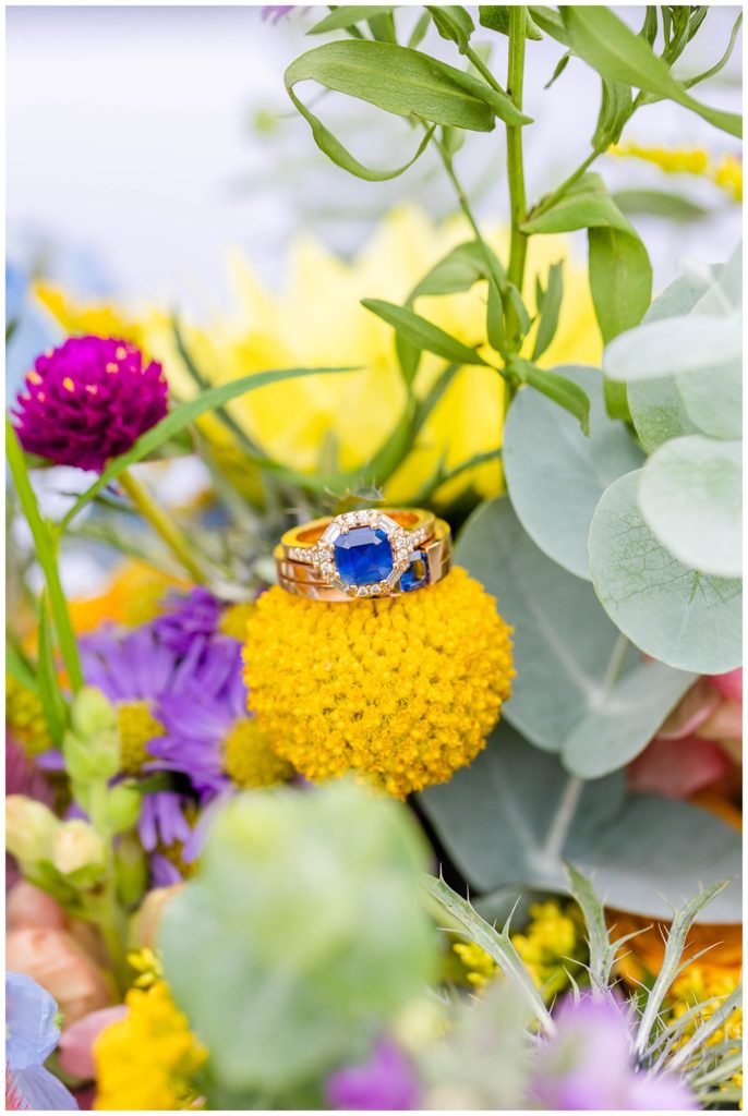 Bright and colorful flowers with blue sapphire wedding bands | Asheville Wedding Photographer