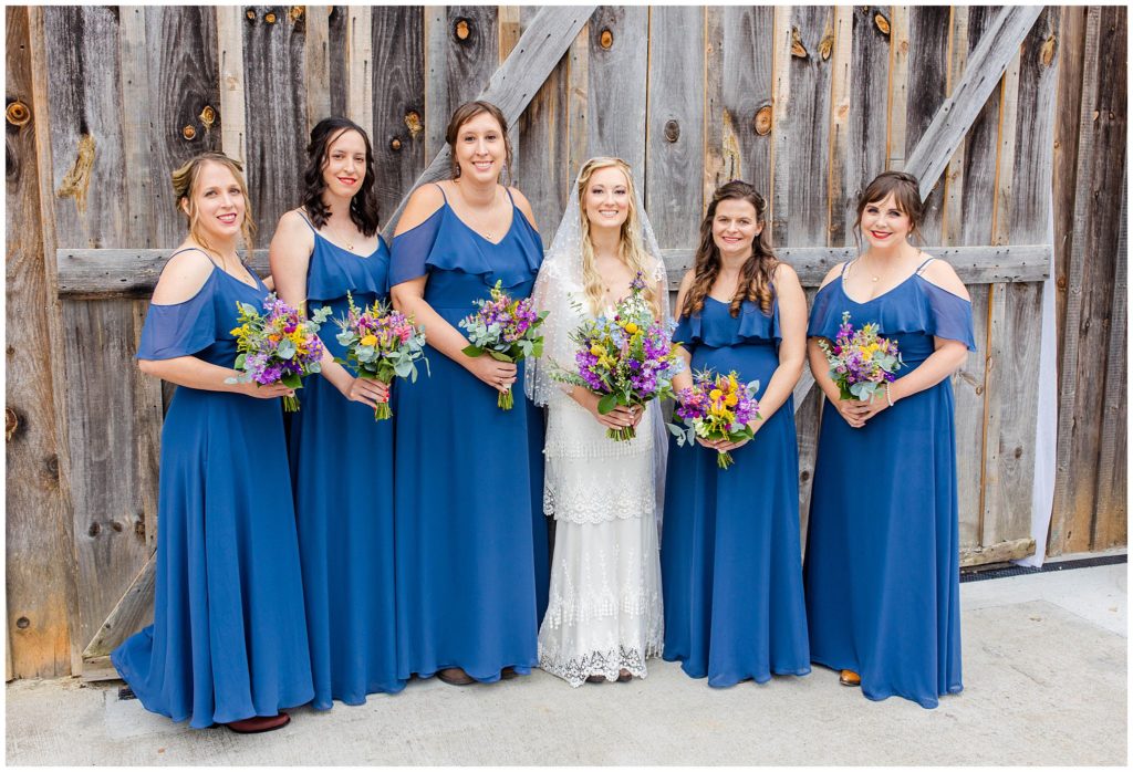 The bride with her bridesmaids with colorful flowers and bright blue dresses | Asheville Wedding Photographer