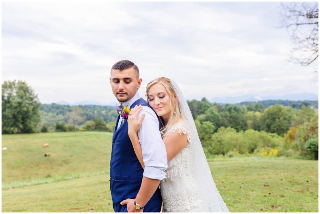 The bride and groom hug at Lewis Farm with mountain views | Asheville Wedding Photographer
