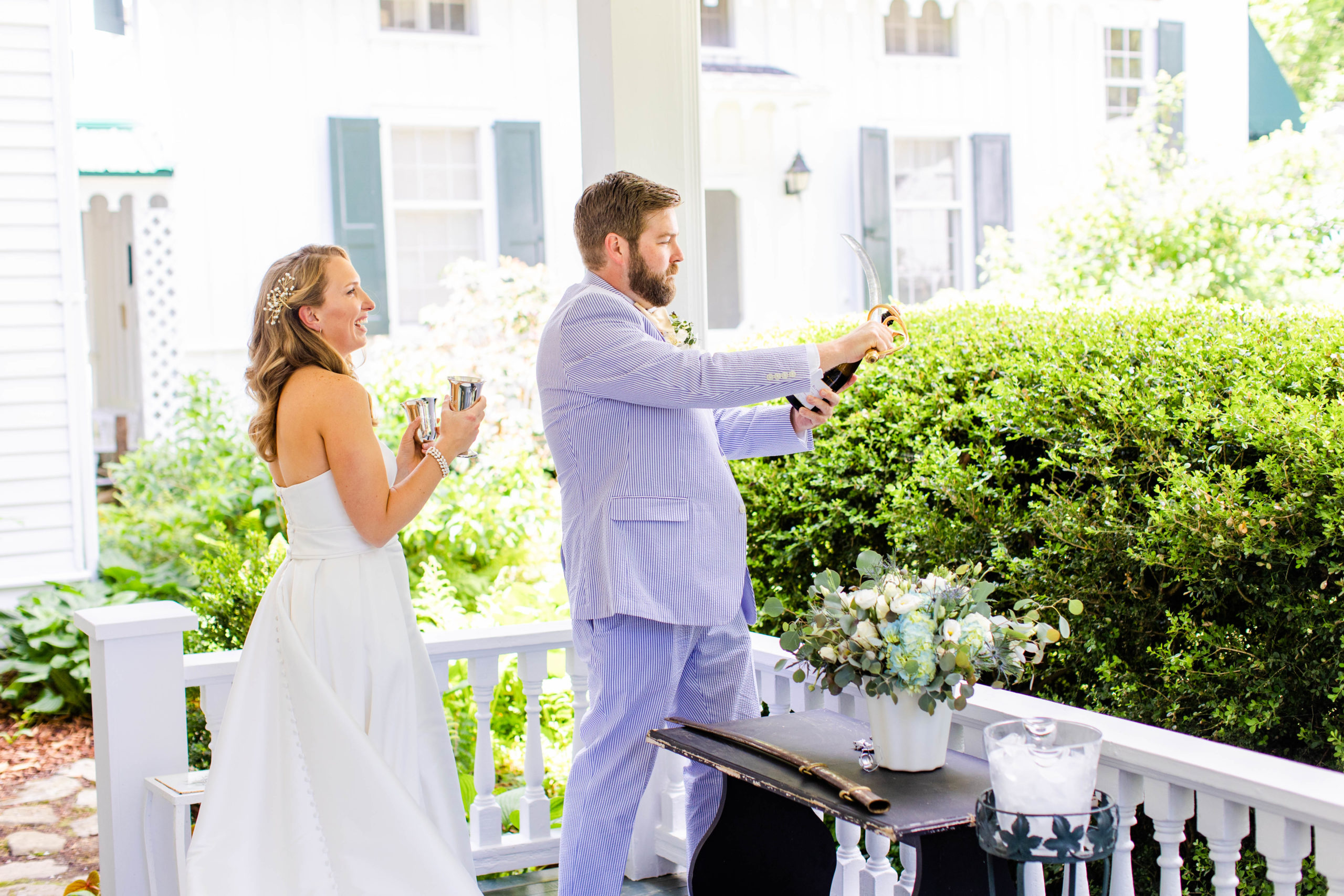 groom pops the champagne outside as bride watches