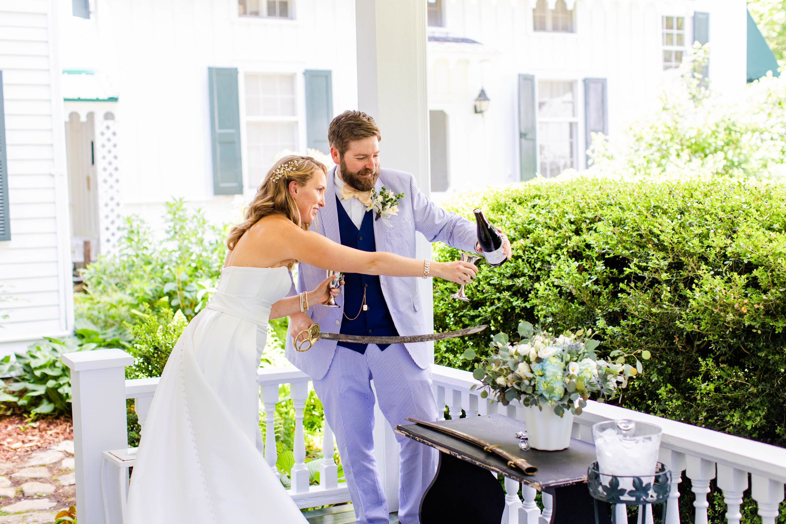 groom pours champagne for bride outside for their wedding