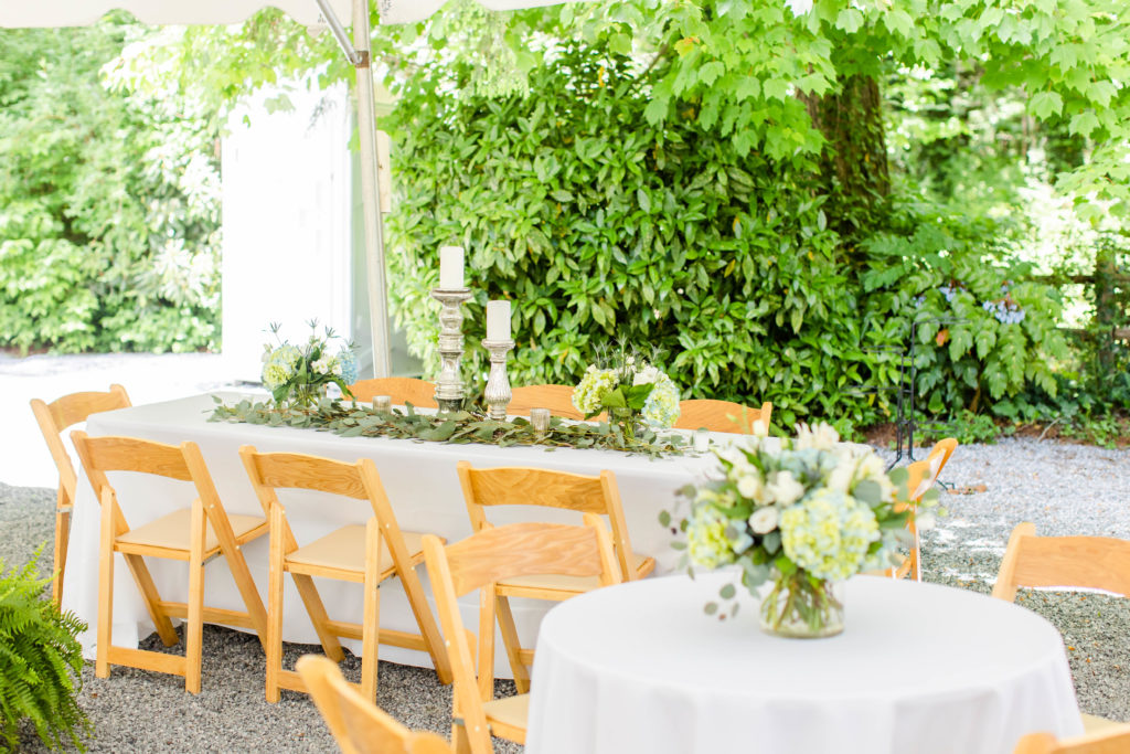 guest tables with white linen under tent for a wedding