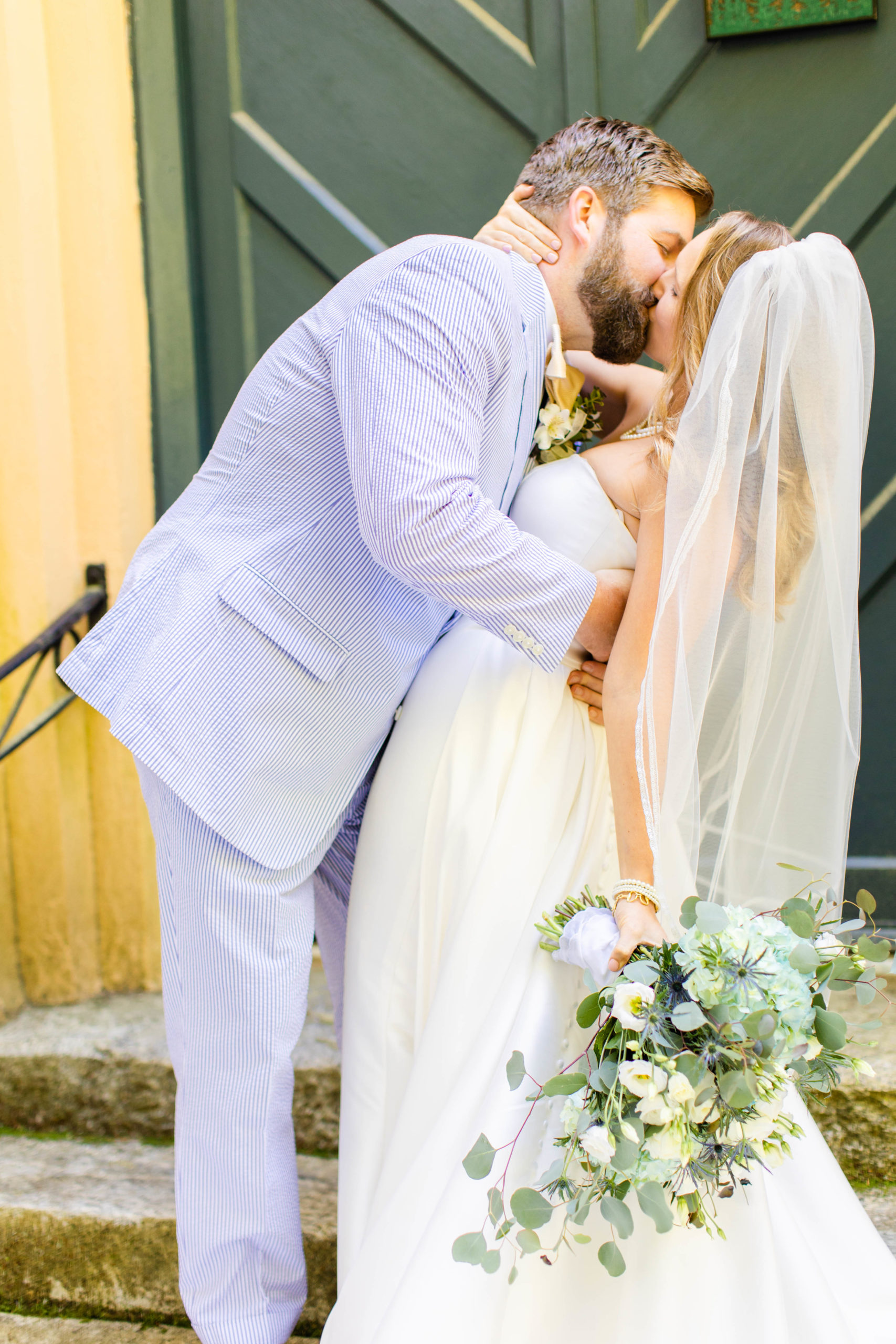 couple kisses outside of chapel doors after their wedding ceremony