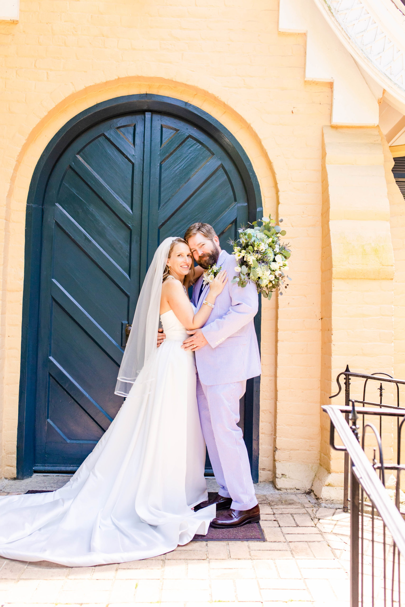 couple poses outside of chapel doors after their wedding ceremony