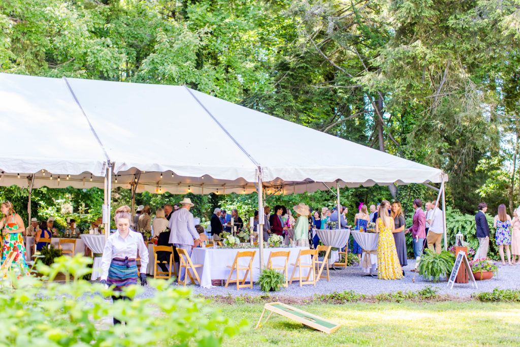 guests mingle under a tent during an intimate wedding in the mountains