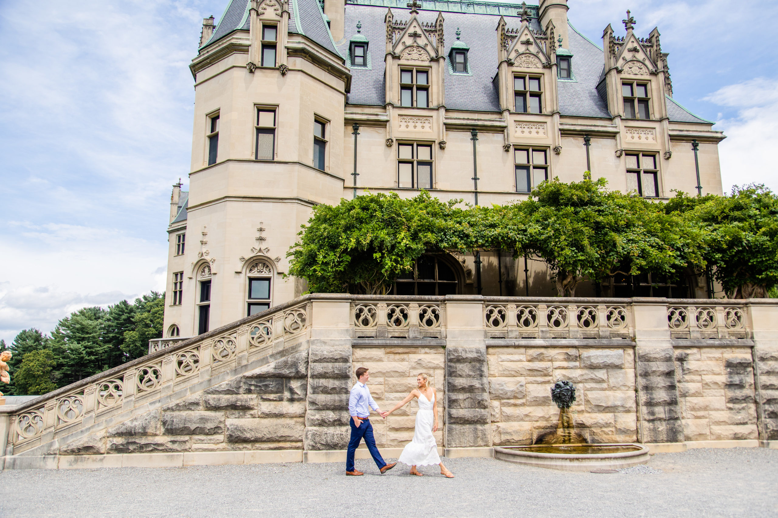 Couple walking next to the Biltmore Estate holding hands