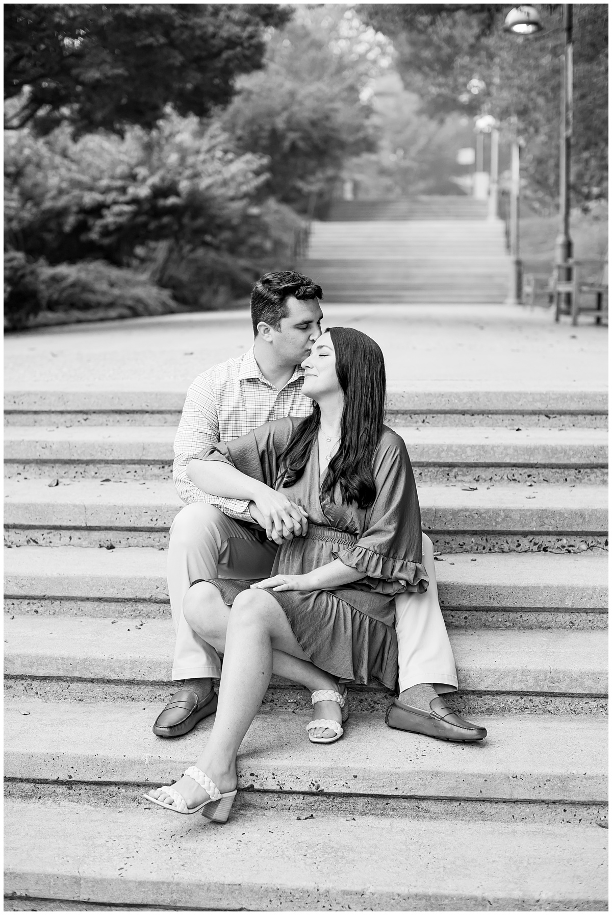 black and white photo of couple sitting on stairs for their outdoor engagement session