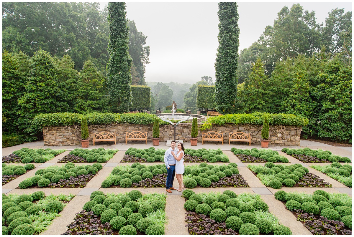 couple poses in NC Arboretum for their engagement session