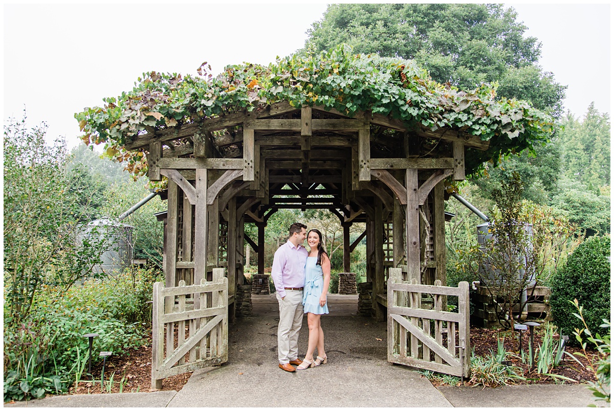 Couple posing under pergola for their engagement session