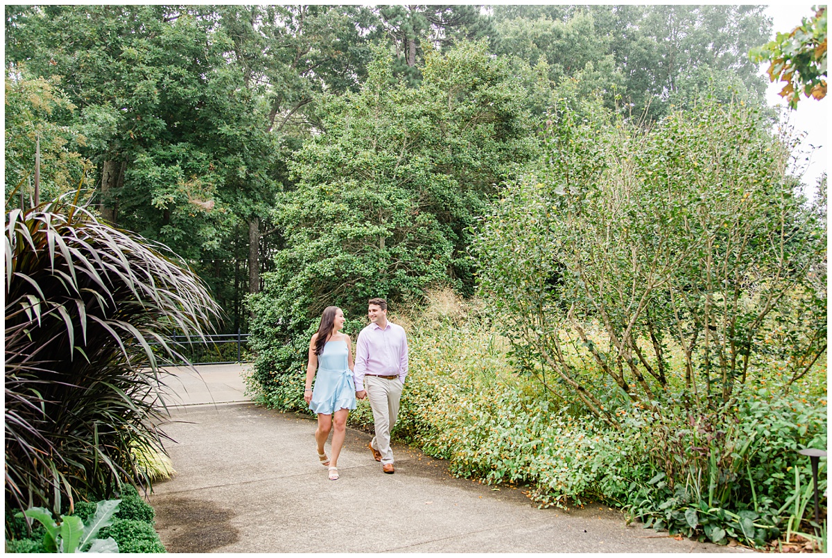 Couple holding hands and walking outdoors for their engagement session