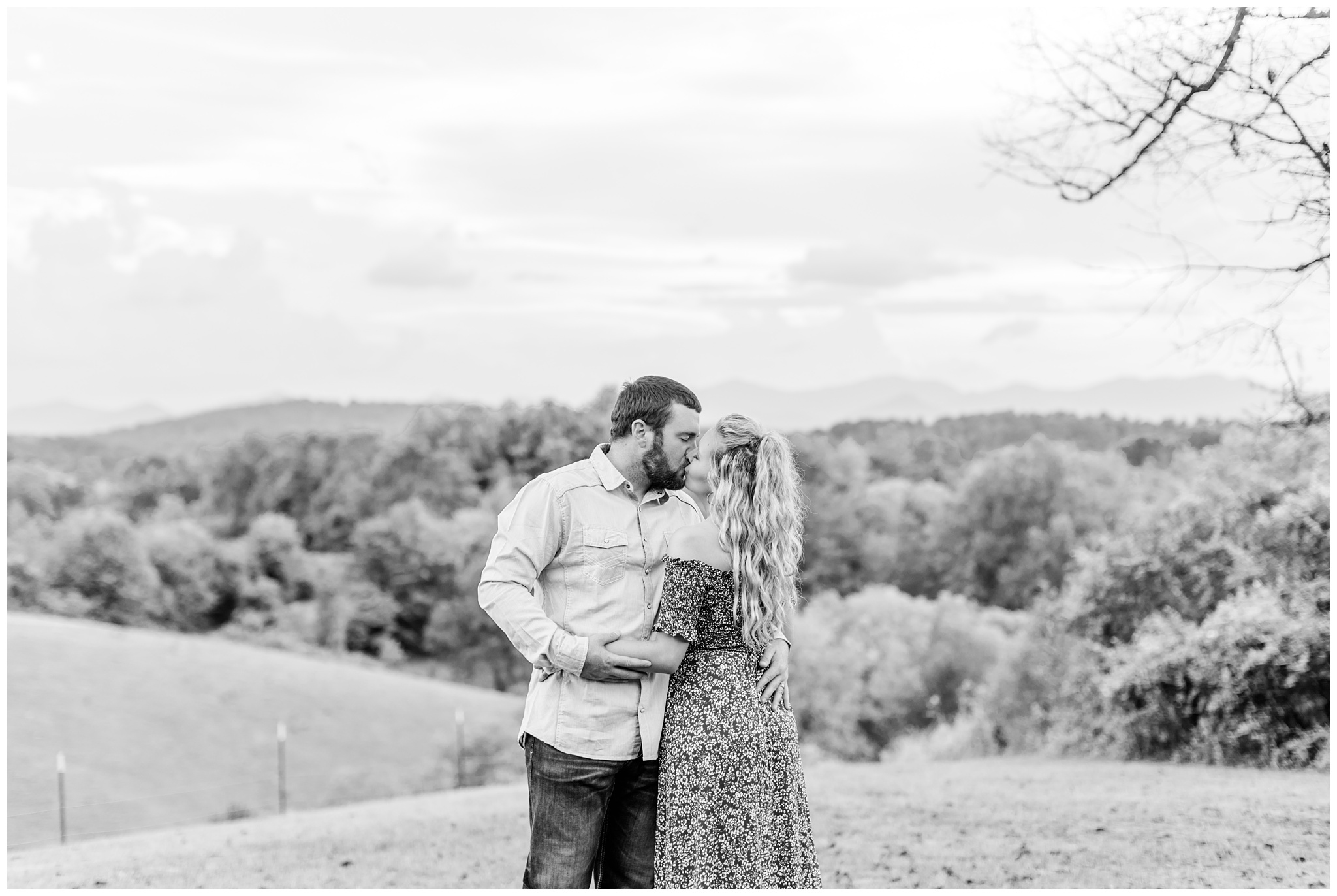 black and white photo of couple kissing on hillside for anniversary session