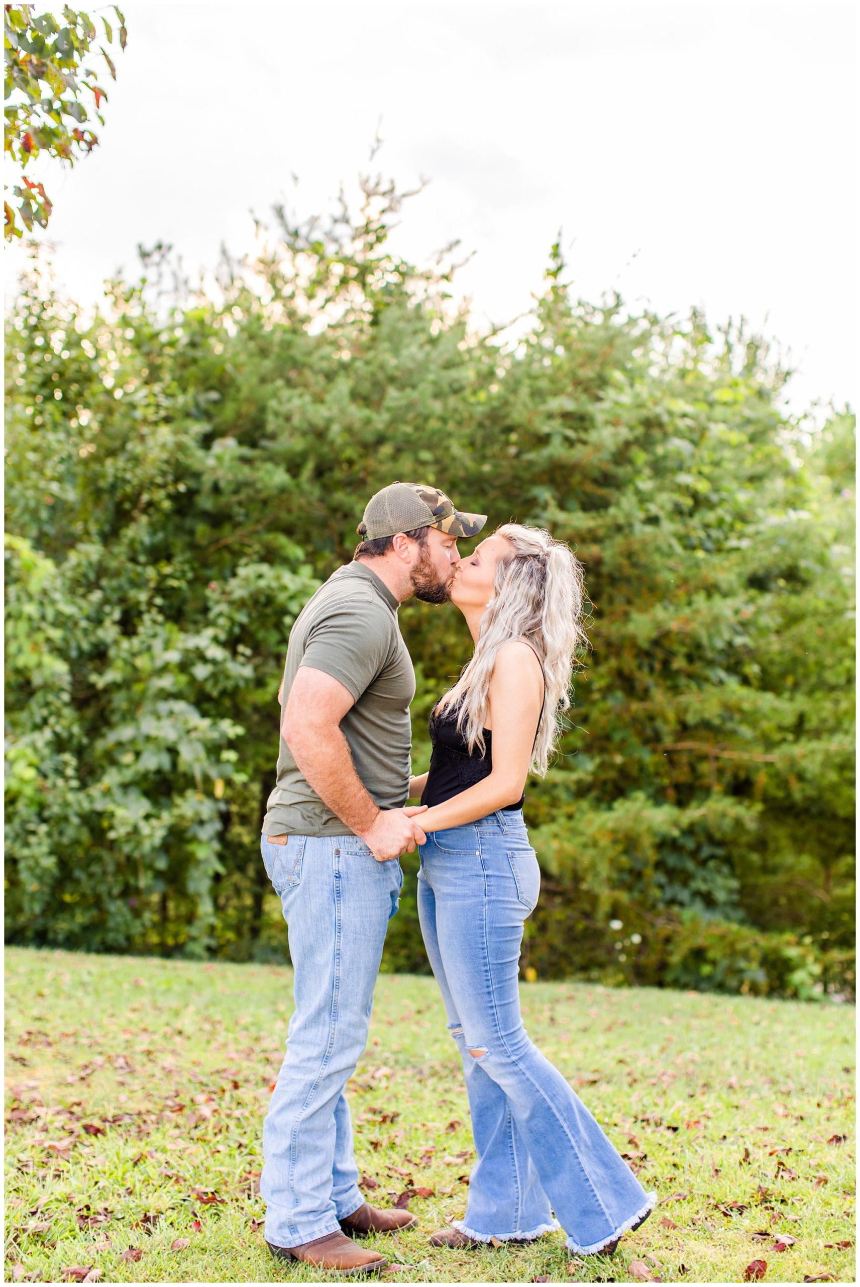 couple kisses outdoors for anniversary photo shoot