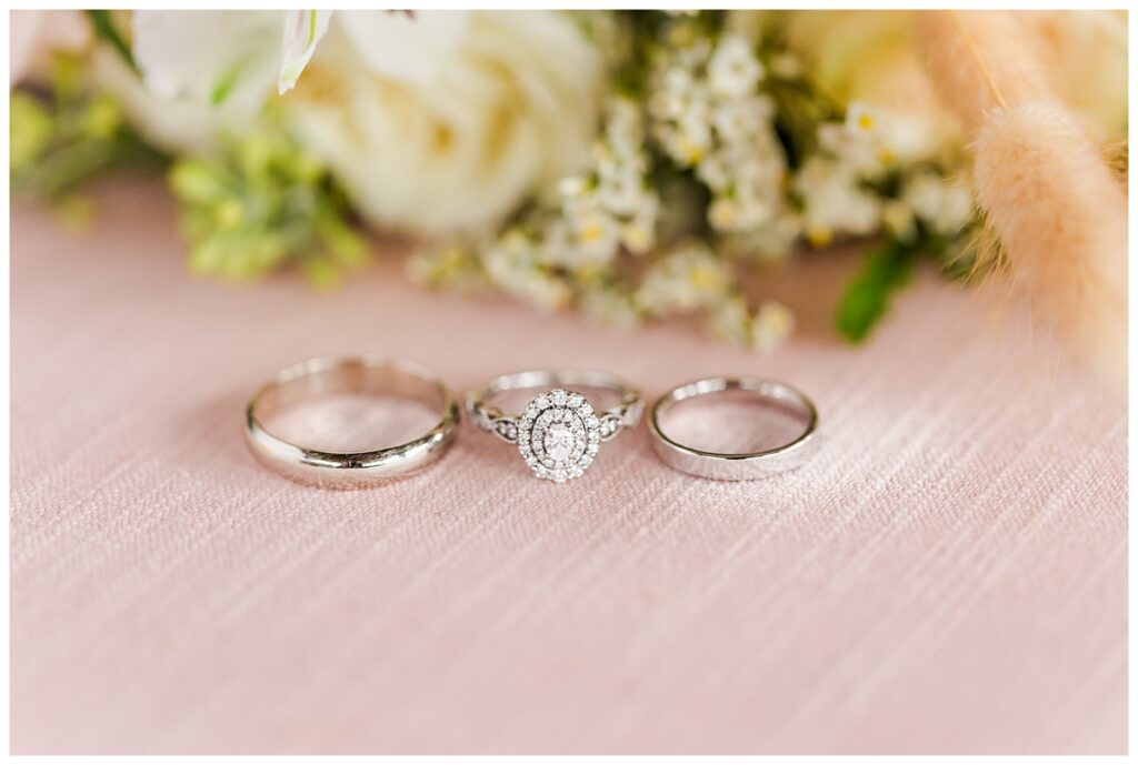 all three wedding rings with florals in the background