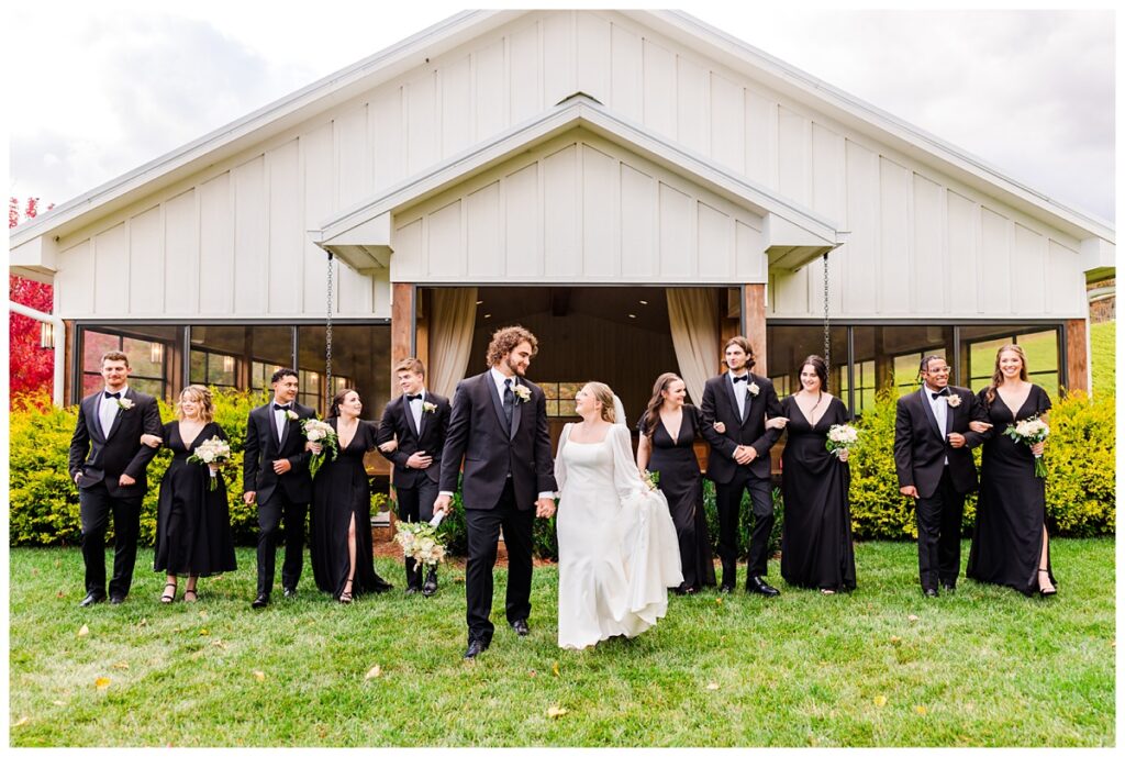 bridal party in black gowns and black tuxedos walking together