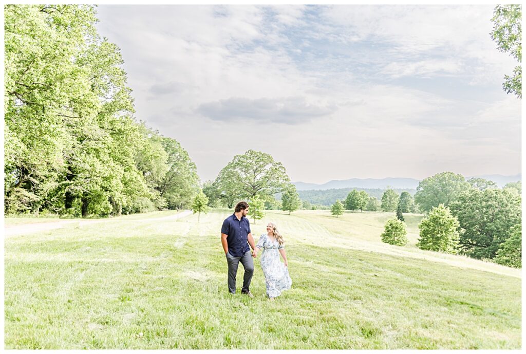 couple walking through field at biltmore estate